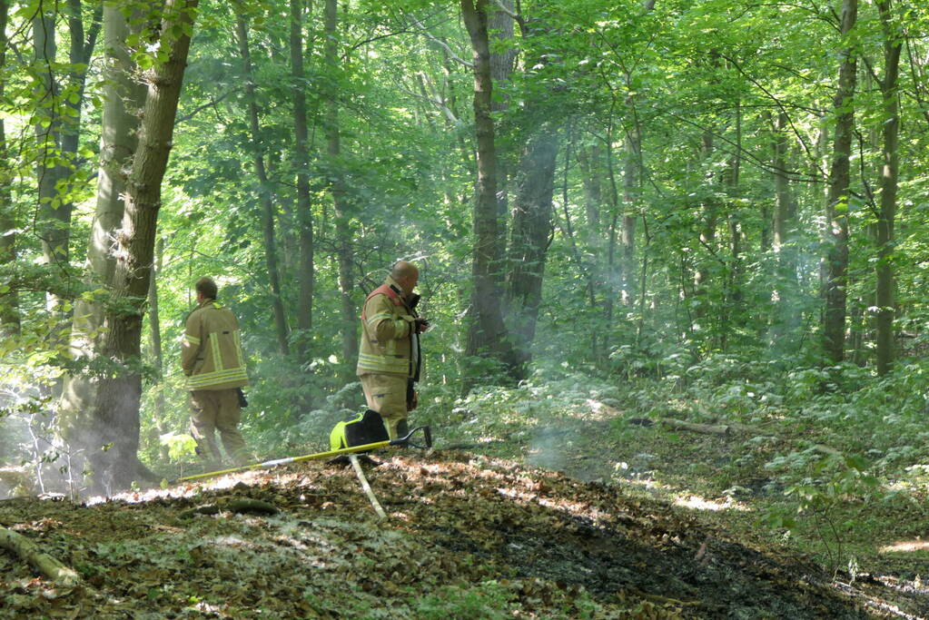 Brandweer blust smeulende delen in duingebied