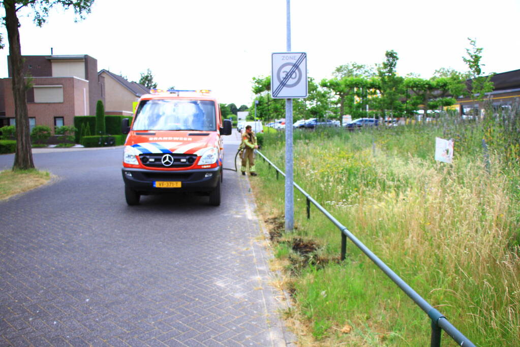 Berm in brand bij winkelcentrum