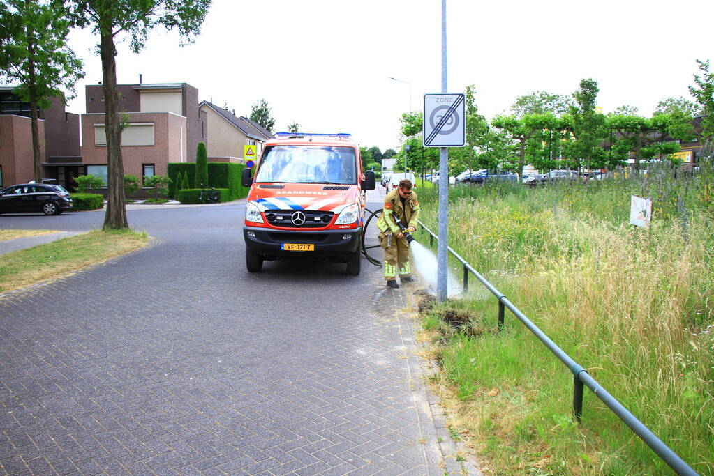 Berm in brand bij winkelcentrum
