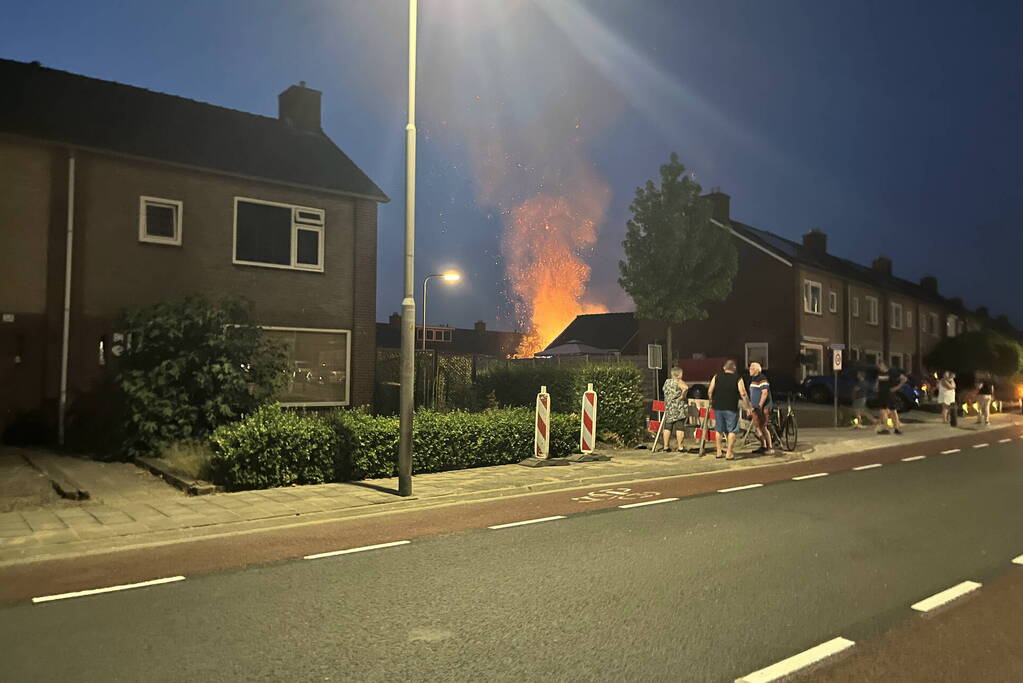 Felle brand in struiken van achtertuin
