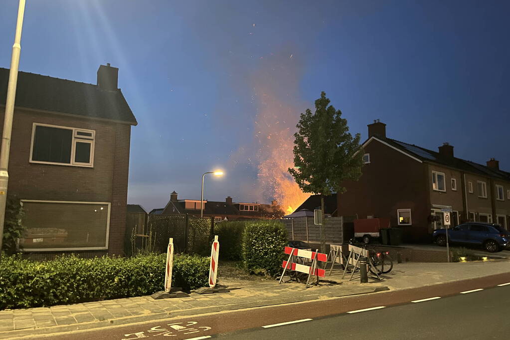 Felle brand in struiken van achtertuin