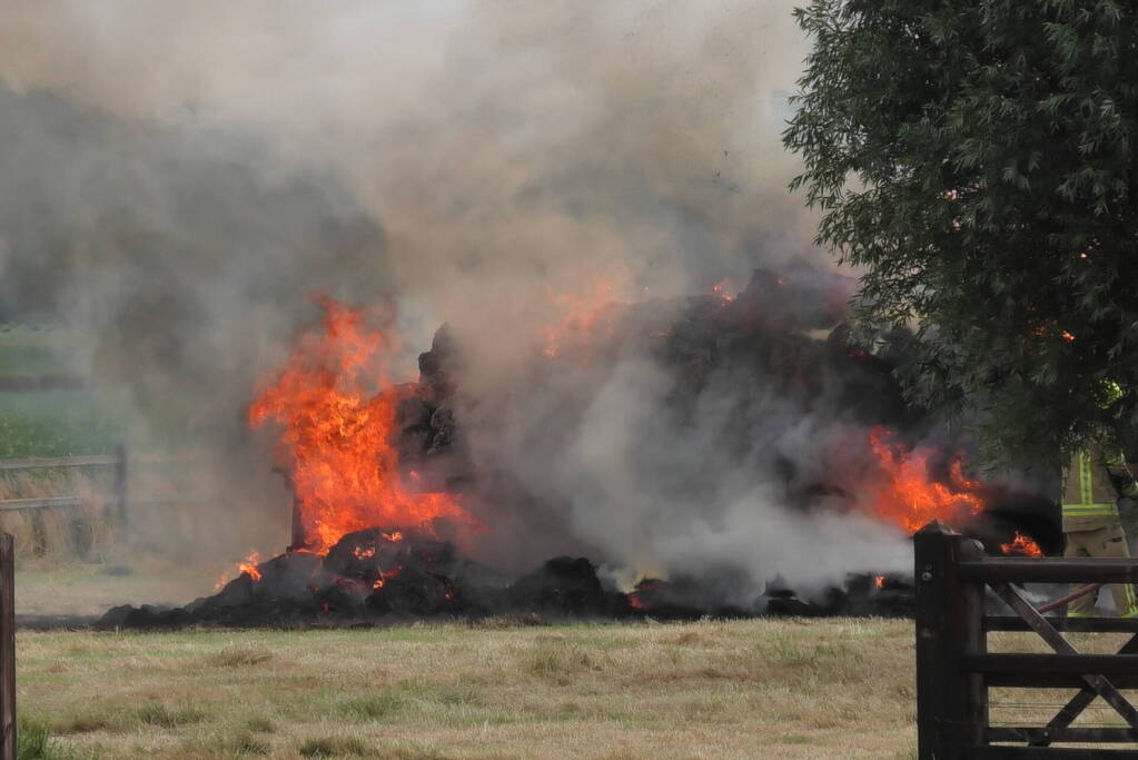 Trailer geladen met hooibalen uitgebrand in weiland