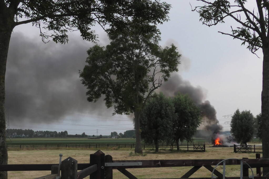 Trailer geladen met hooibalen uitgebrand in weiland