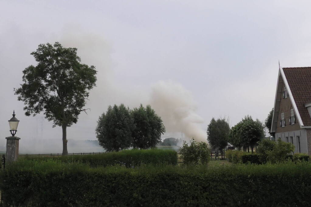 Trailer geladen met hooibalen uitgebrand in weiland