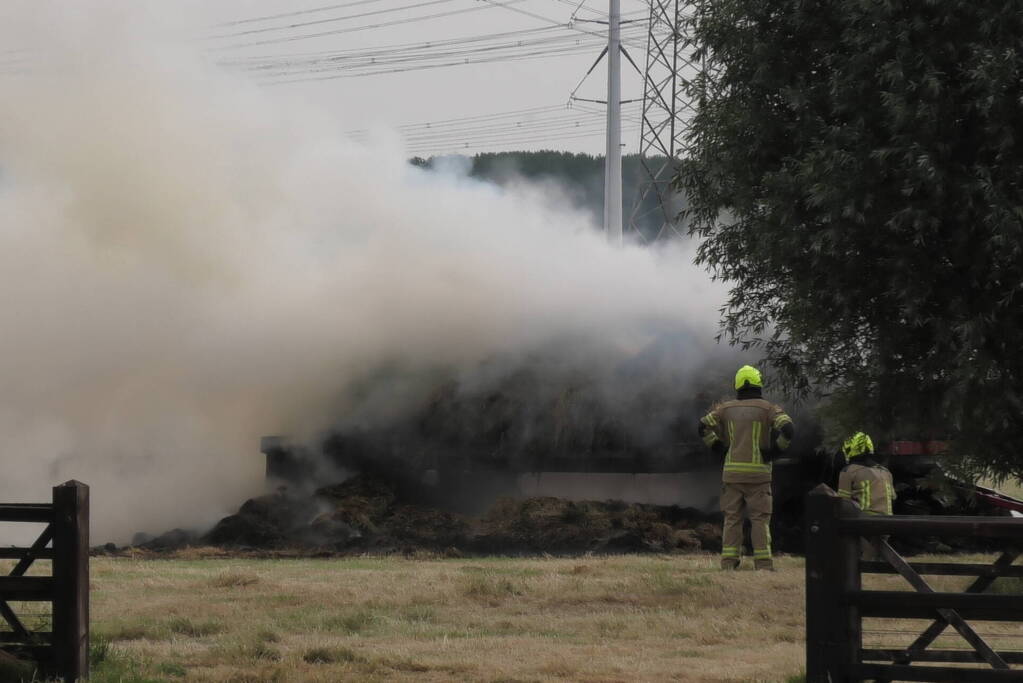 Trailer geladen met hooibalen uitgebrand in weiland