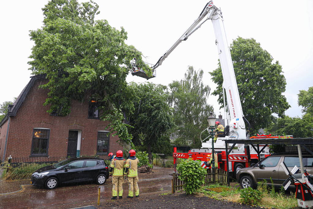 Flinke boom omgewaaid tegen woning