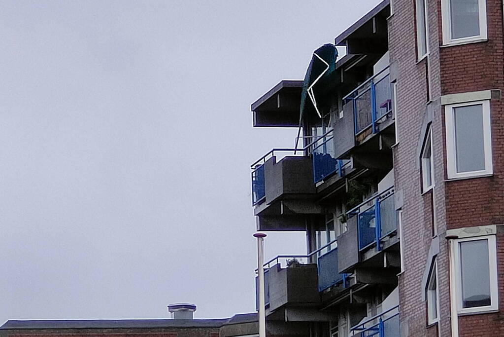 Brandweer verwijderd losgewaaid zonnescherm