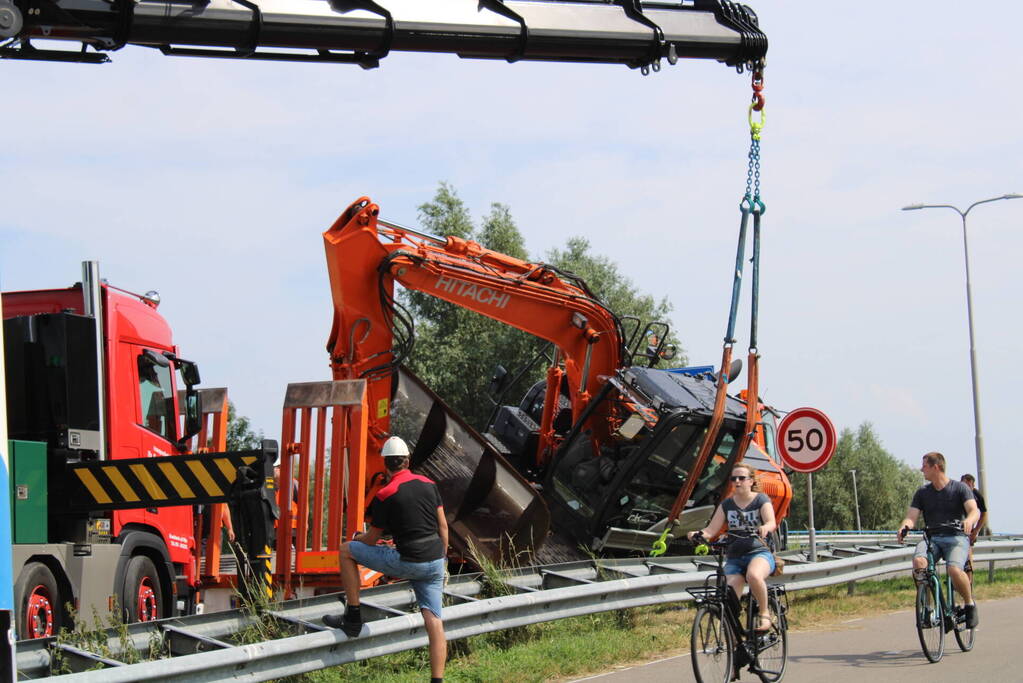 Graafkraan valt van dieplader