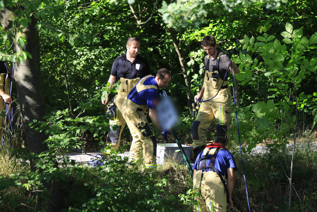 Brandweer haalt fiets en verkeersbord uit water