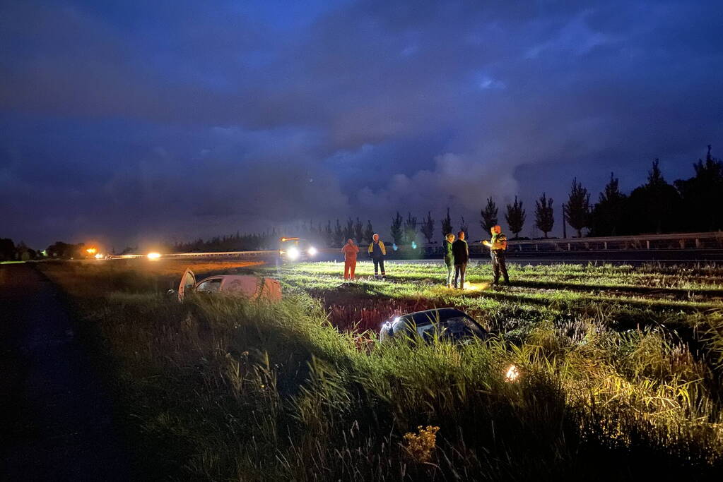 Busje en auto belanden in sloot