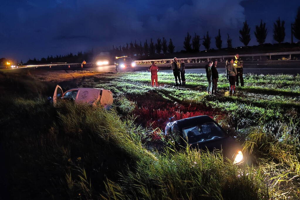 Busje en auto belanden in sloot