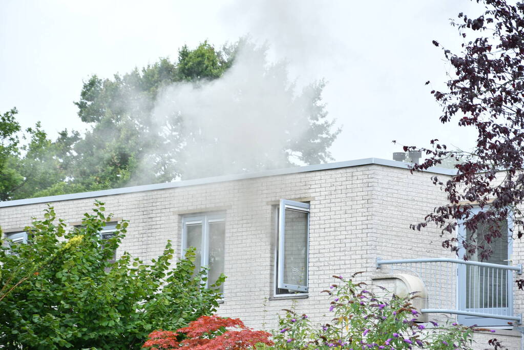 Zwarte rook uit woning door brand