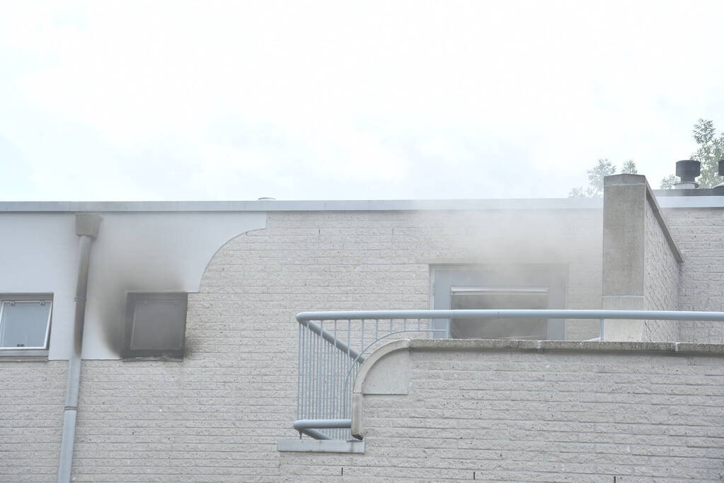Zwarte rook uit woning door brand