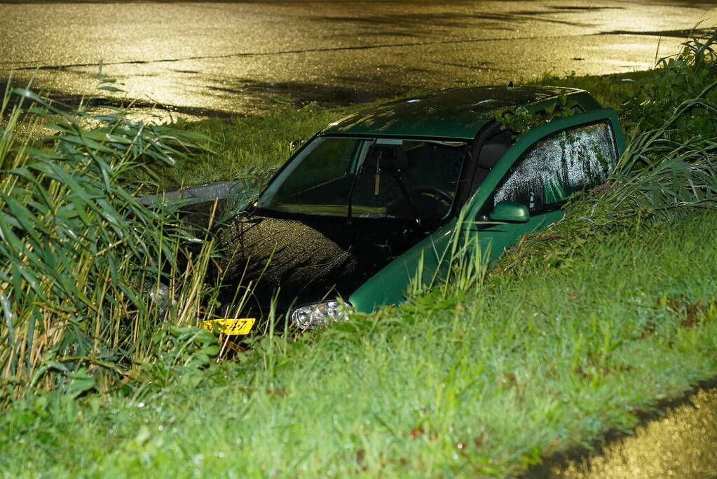 Auto glijdt de bocht uit in een sloot