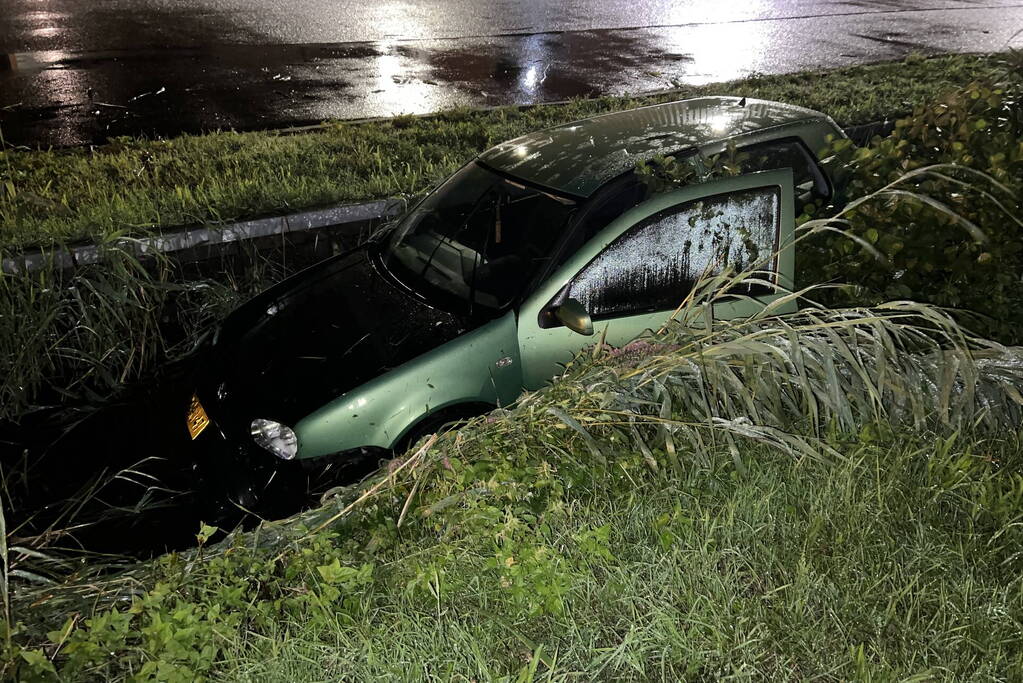 Auto glijdt de bocht uit in een sloot