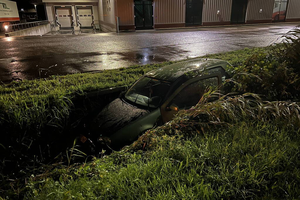 Auto glijdt de bocht uit in een sloot