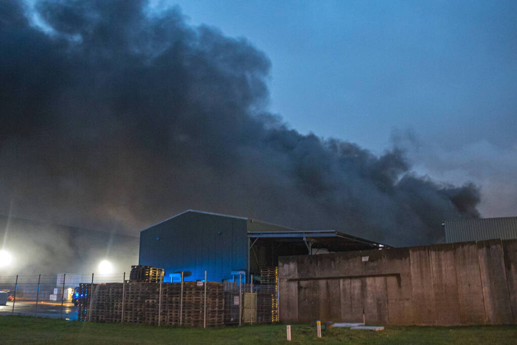 Zwarte rookpluimen boven havengebied door grote brand