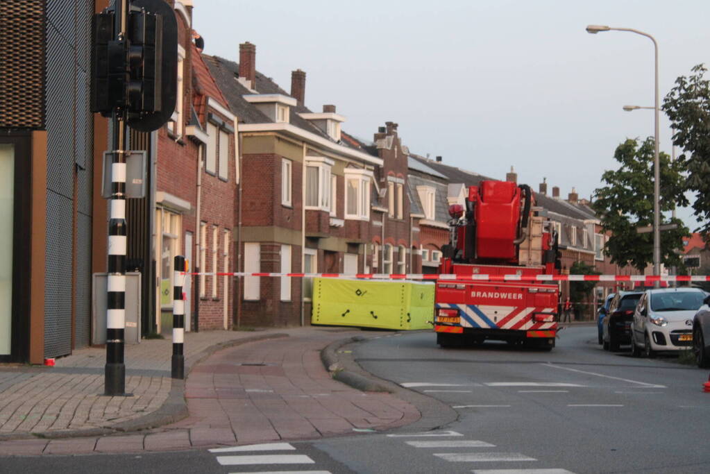 Man klimt op woning en gooit dakpannen naar hulpdiensten
