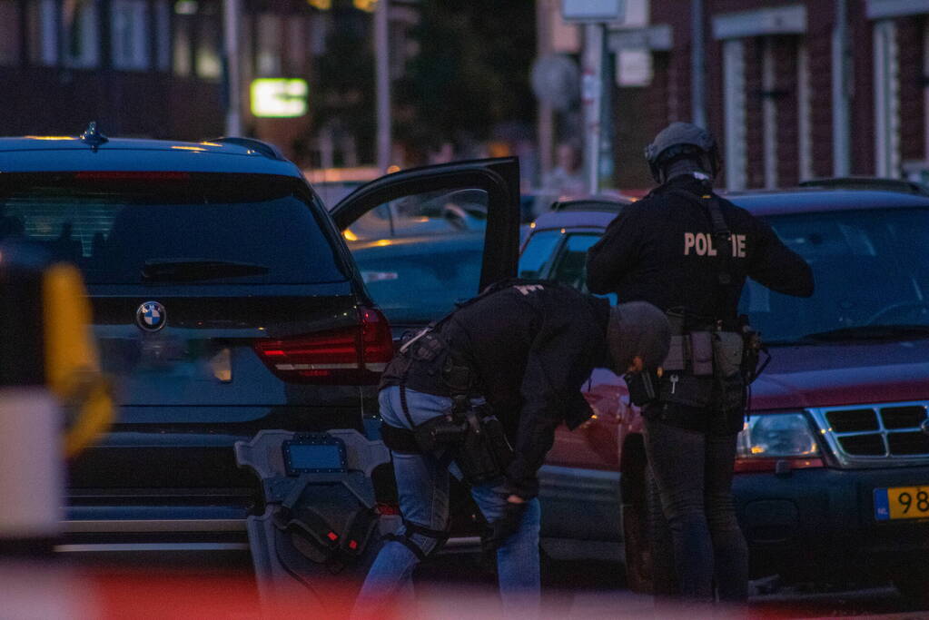 Man klimt op woning en gooit dakpannen naar hulpdiensten