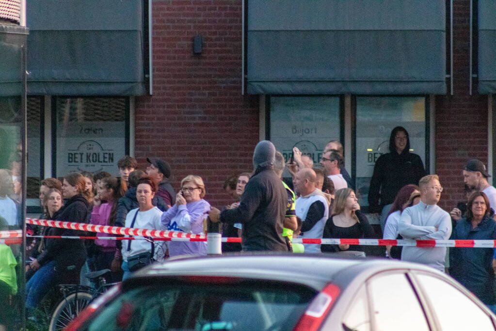 Man klimt op woning en gooit dakpannen naar hulpdiensten