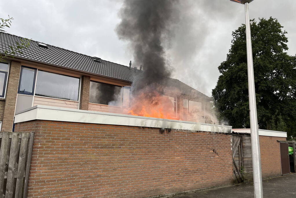 Uitslaande brand in schuur slaat over naar woning