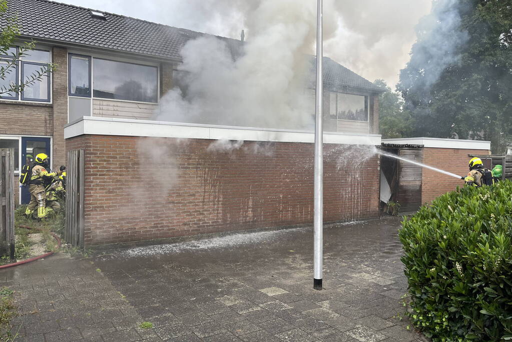 Uitslaande brand in schuur slaat over naar woning
