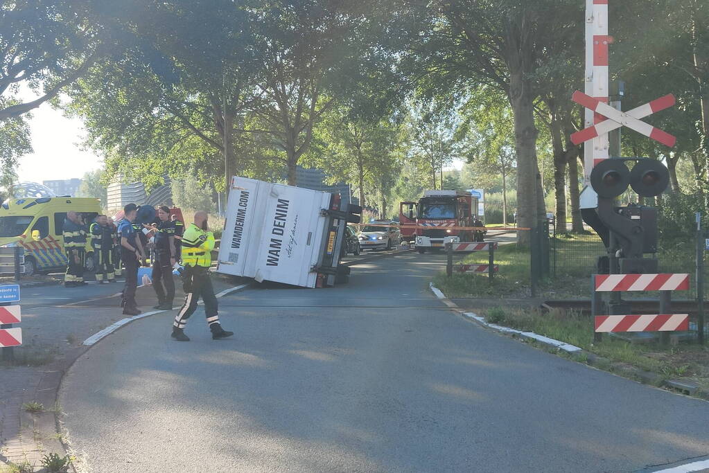Vrachtwagen kantelt in bocht op overweg