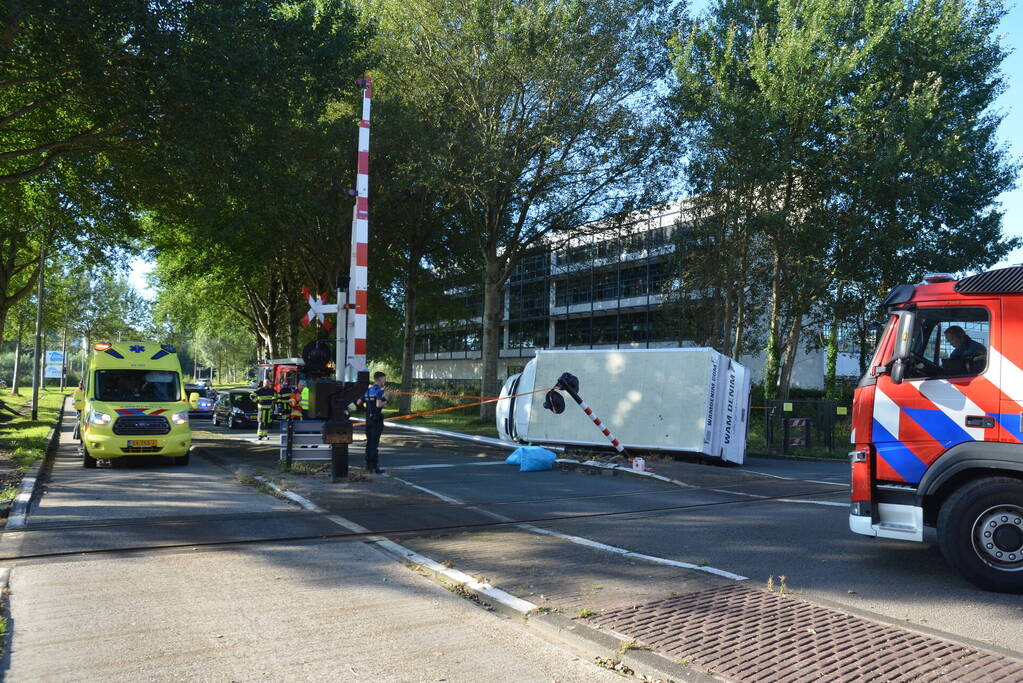 Vrachtwagen kantelt in bocht op overweg