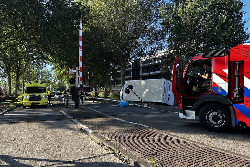 Vrachtwagen kantelt in bocht op overweg