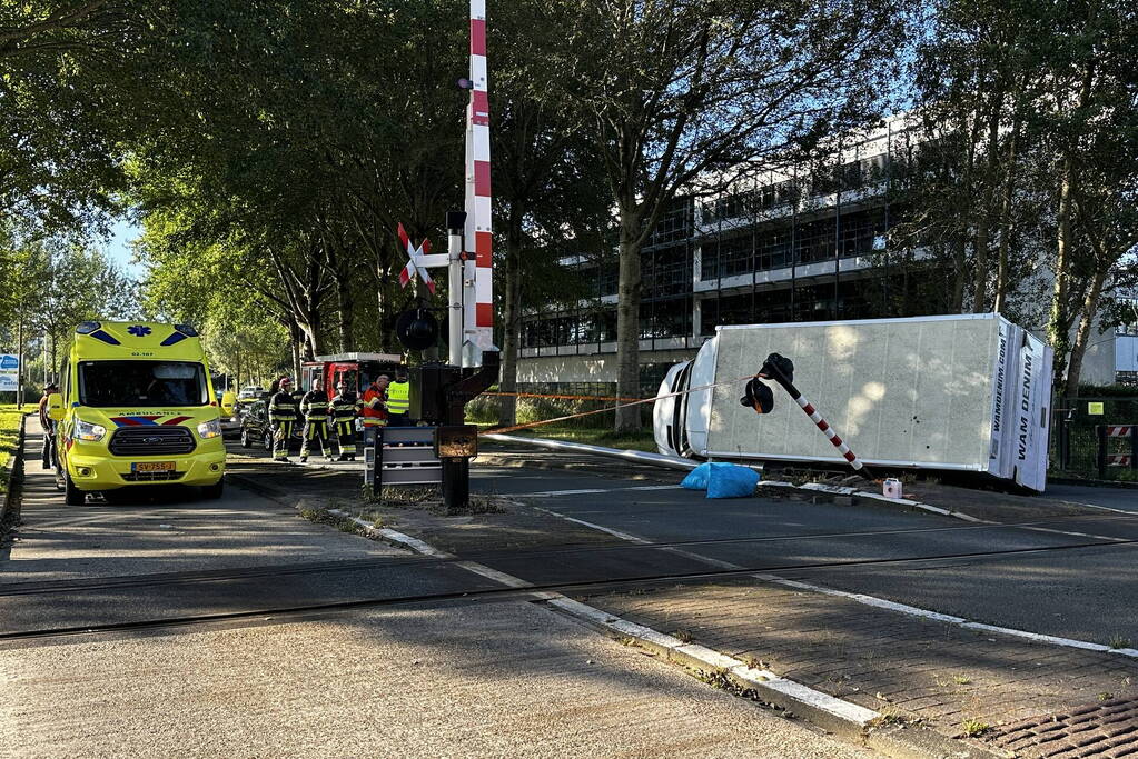 Vrachtwagen kantelt in bocht op overweg
