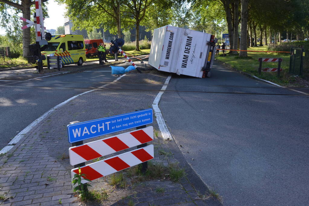 Vrachtwagen kantelt in bocht op overweg