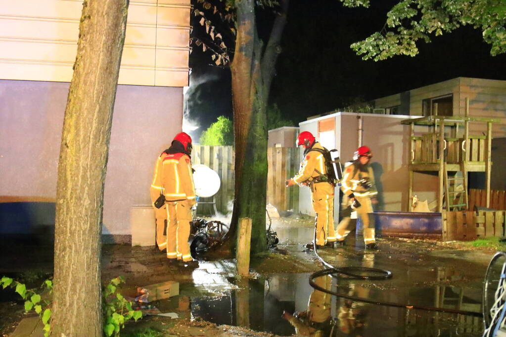 Scooter in brand tegen woning