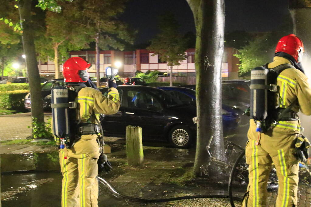 Scooter in brand tegen woning