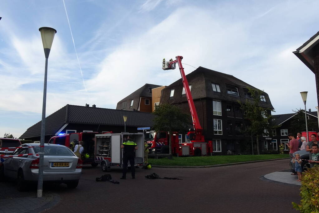 Brand op dak van appartementencomplex met rietendak