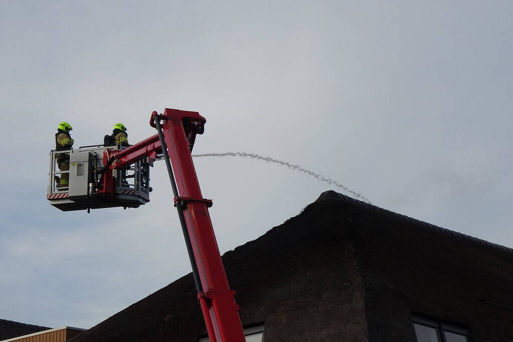 Brand op dak van appartementencomplex met rietendak