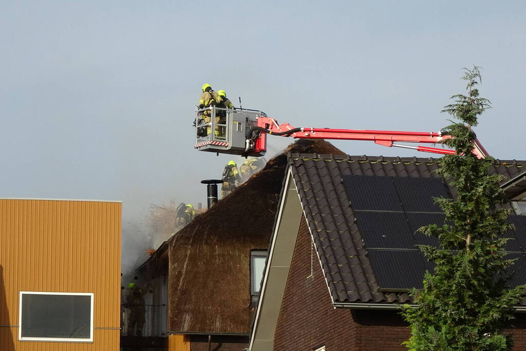Brand op dak van appartementencomplex met rietendak