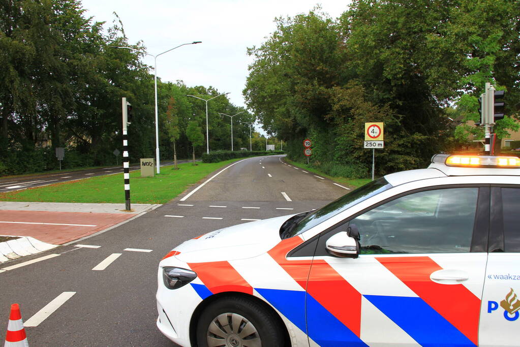 Vrachtwagen geladen met betonplaten vast onder spoorbrug