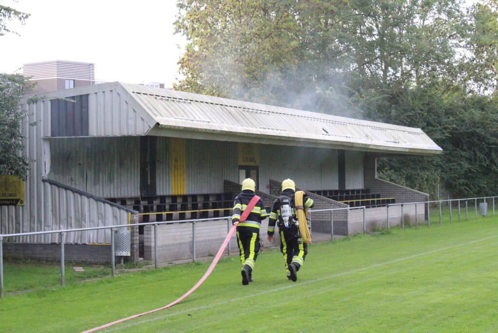 Brandweer blust brand onder voetbaltribune