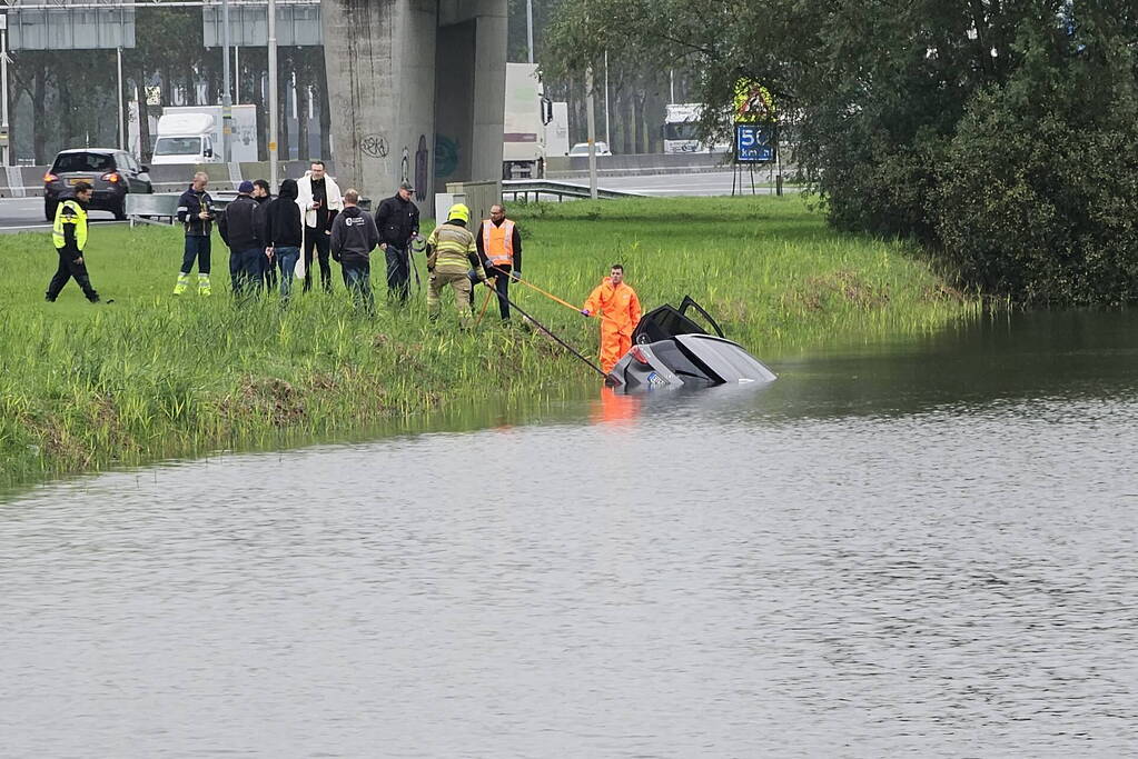 Auto raakt te water naast snelweg