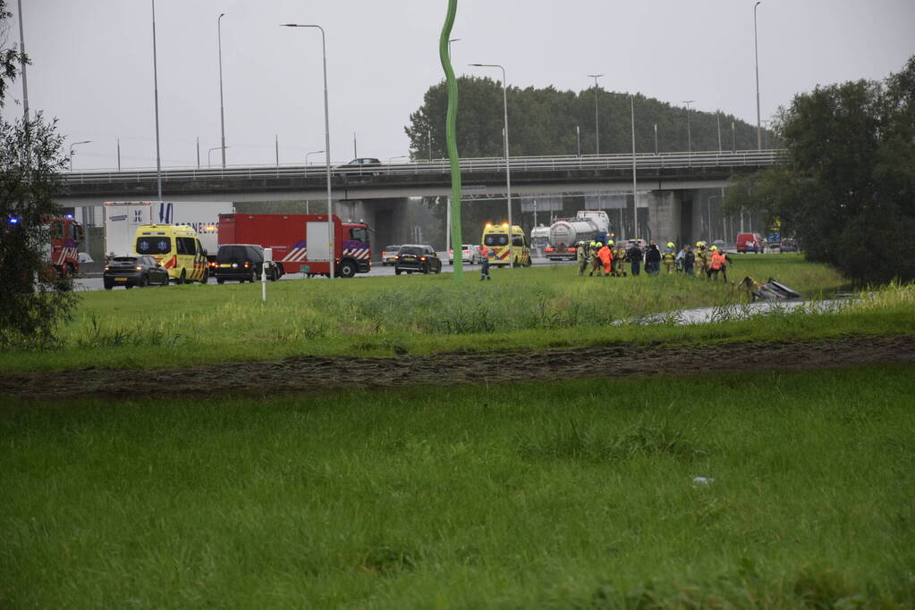 Auto raakt te water naast snelweg