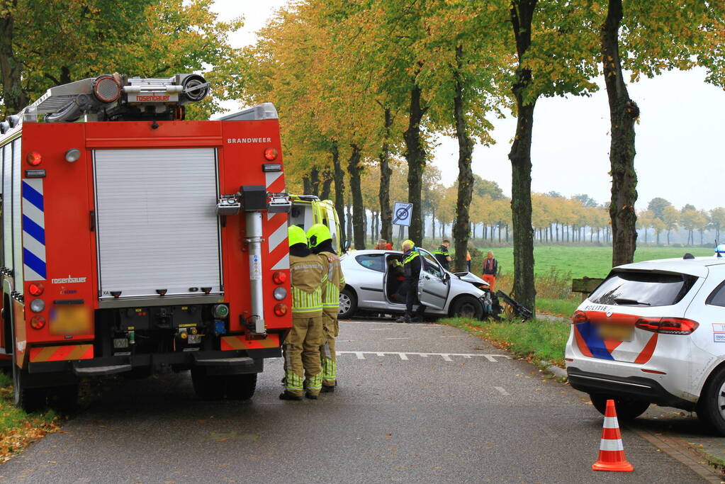 Bestuurder bekneld bij botsing tegen boom
