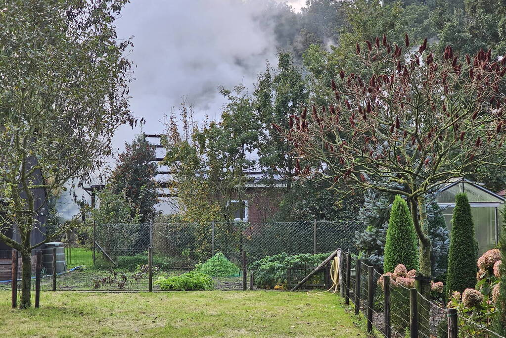 Grote brand in loods dreigt over te slaan naar woning
