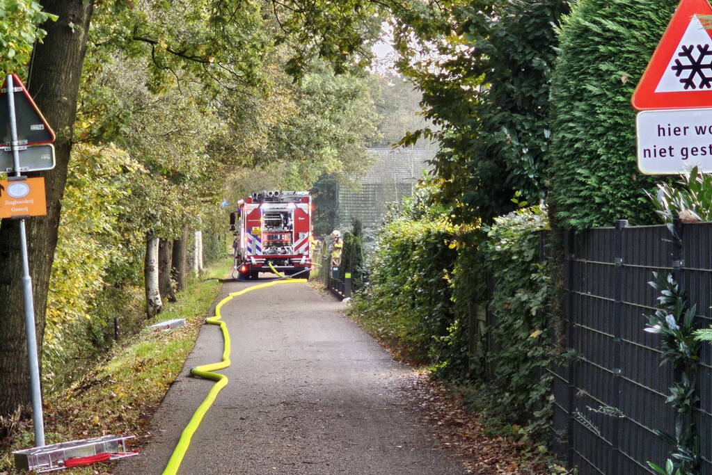 Grote brand in loods dreigt over te slaan naar woning