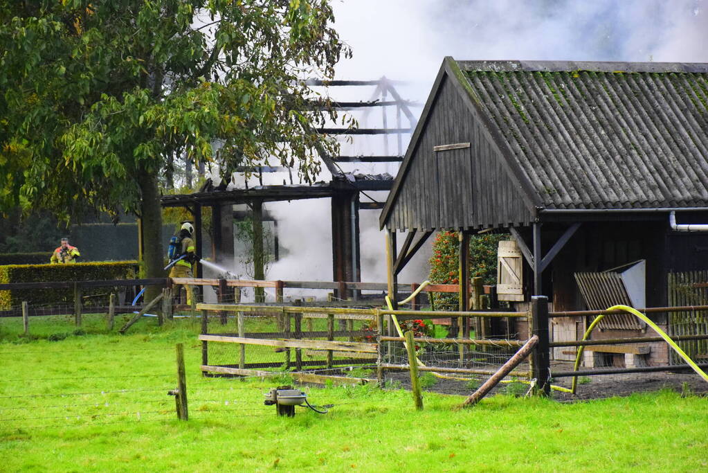 Grote brand in loods dreigt over te slaan naar woning