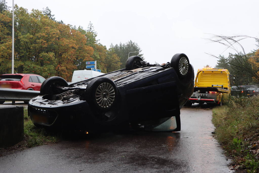 Auto vliegt over vangrail en belandt op kop