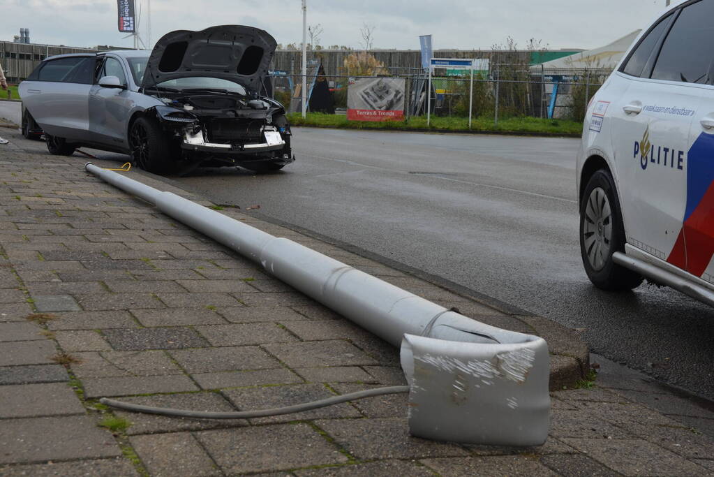 Personenauto klapt op lantaarnpaal