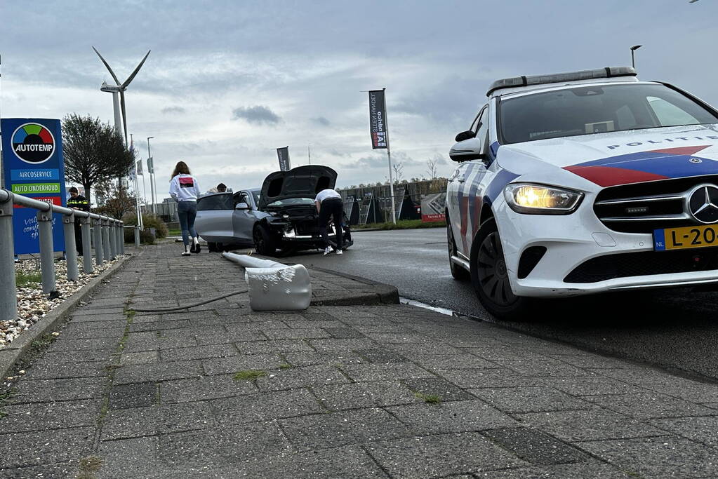 Personenauto klapt op lantaarnpaal