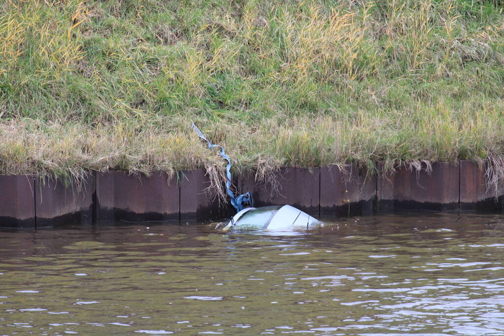 Personenauto rolt kanaal in