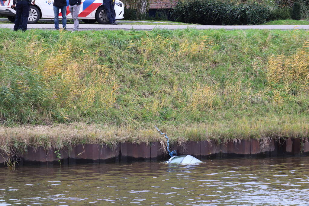 Personenauto rolt kanaal in