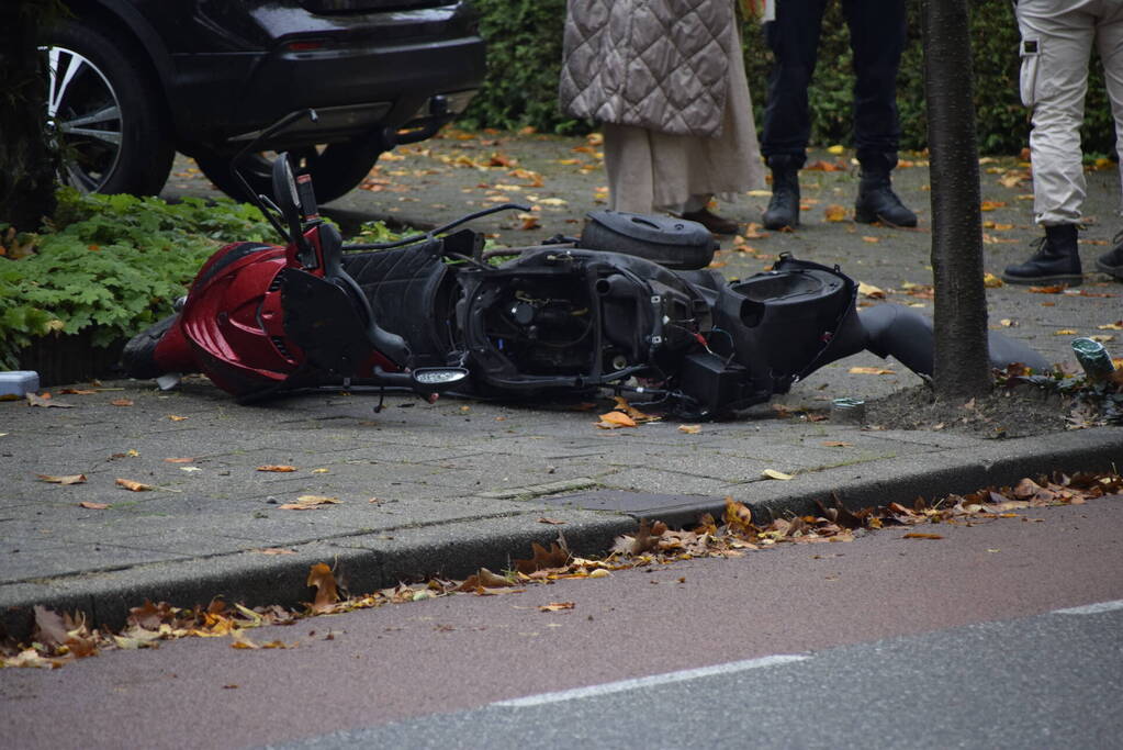 Overstekende scooter geschept door auto